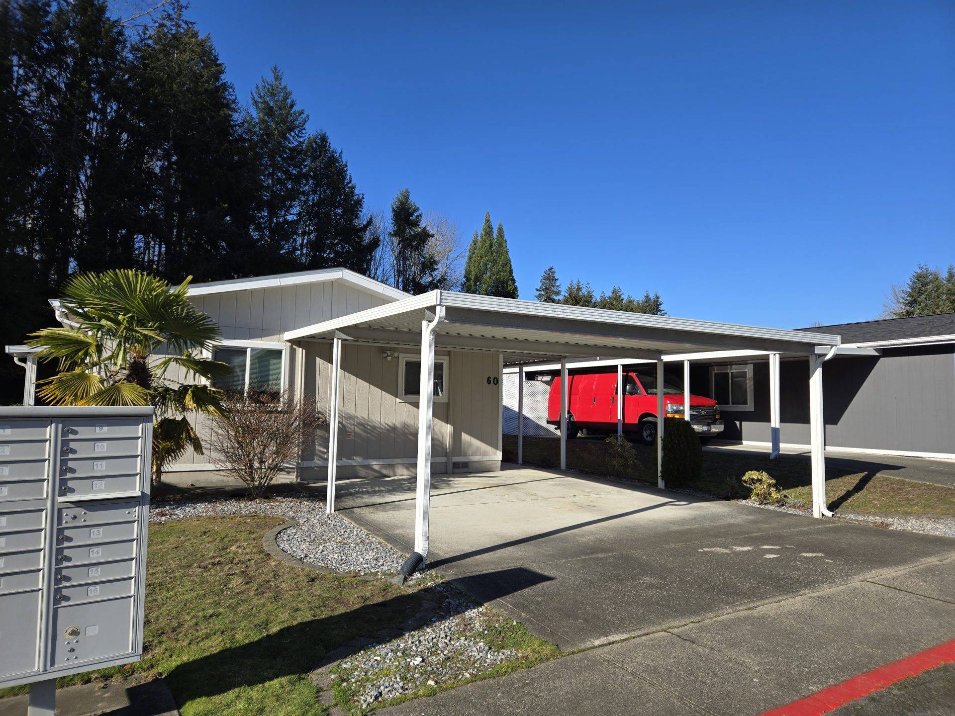 A house featuring a covered porch and several mailboxes in front, set in a residential neighborhood.